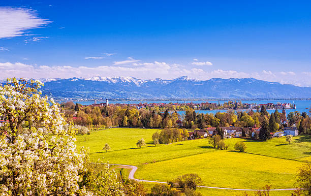 Lindau and Austrian Alps at Lake Constance (Bodensee) at spring Elevated view on the beautiful bavarian island town of Lindau at Lake Constance (Bodensee), with blooming apple trees and the snow-covered Austrian alps and town of Bregenz at the distance. bodensee stock pictures, royalty-free photos & images