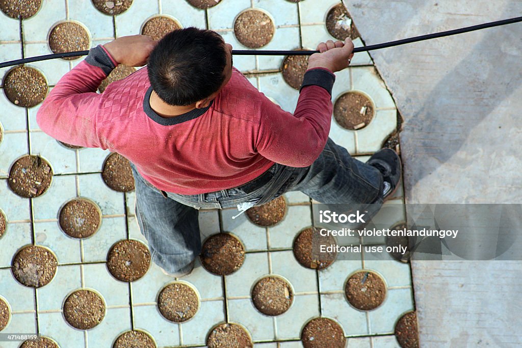 Uomo tirando via cavo, Cina - Foto stock royalty-free di Adulto