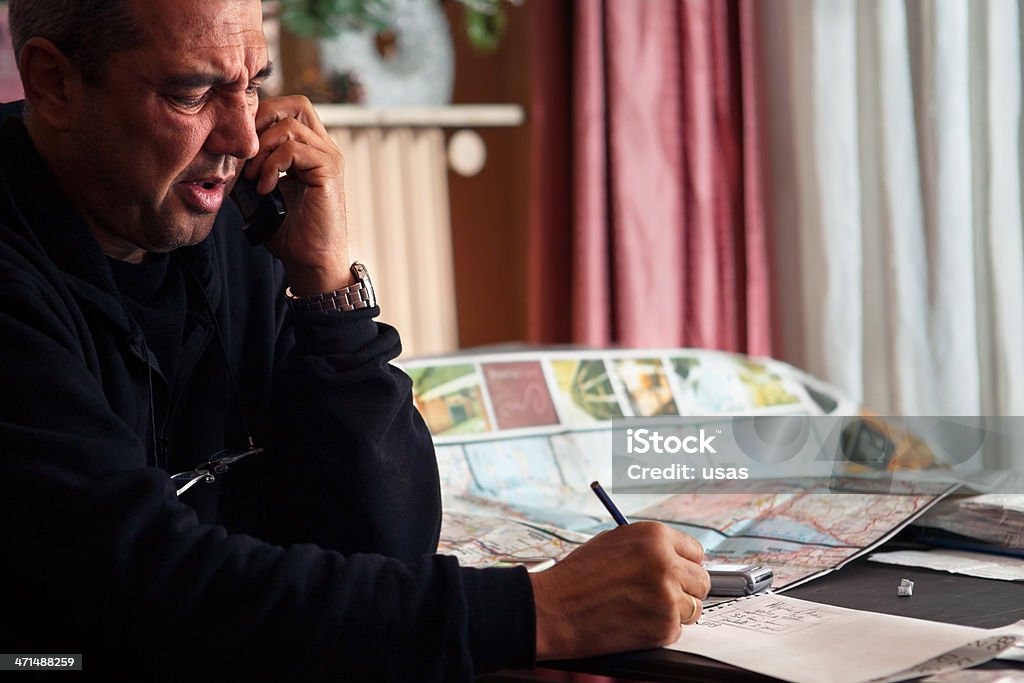 Homem falando no telefone e jotting - Foto de stock de 50 Anos royalty-free