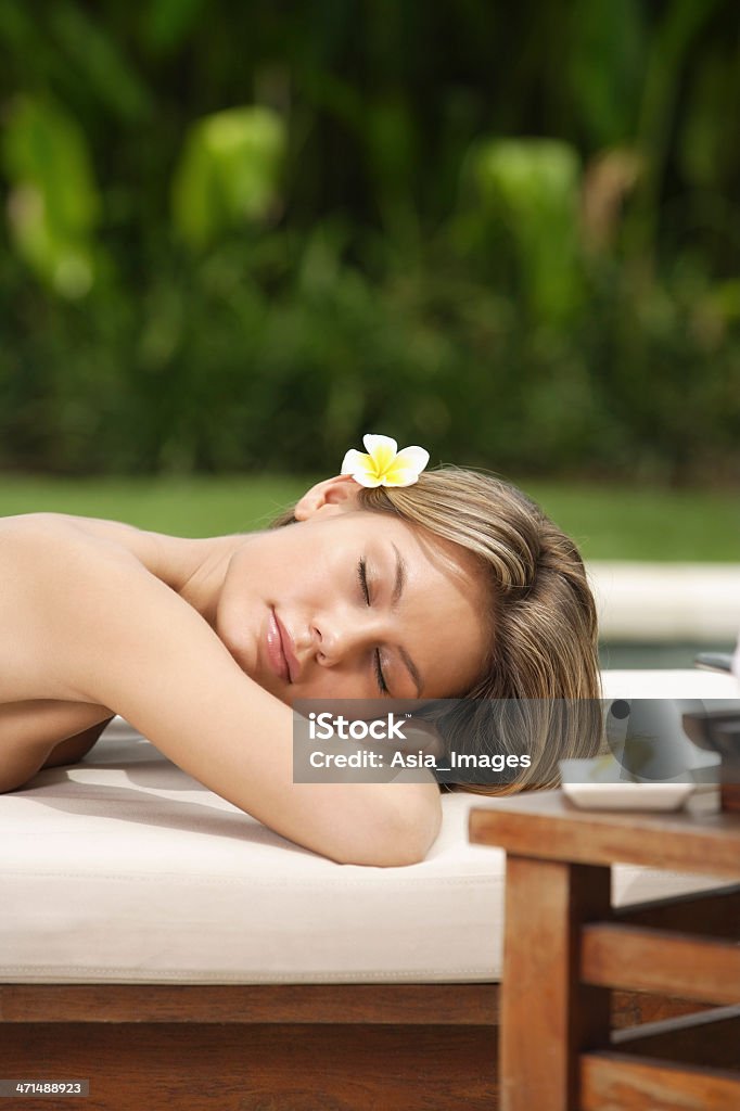 Donna sdraiata in sole sul tavolo per massaggi - Foto stock royalty-free di 20-24 anni