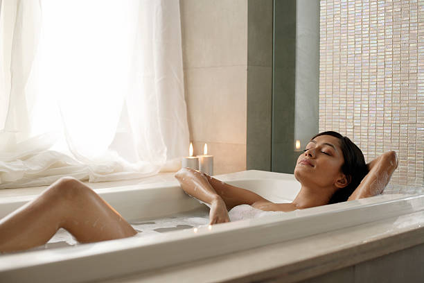donna sdraiato nella vasca da bagno - bathtub asian ethnicity women female foto e immagini stock