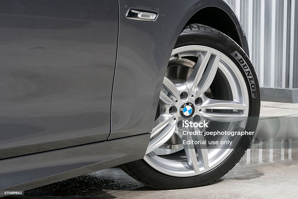 BMW 520d Wheel with DUNLOP tire Chiang Mai,Thailand - December 20, 2012:The front wheel of a BMW 520d saloon parked on display outside of a car dealership. BMW Stock Photo