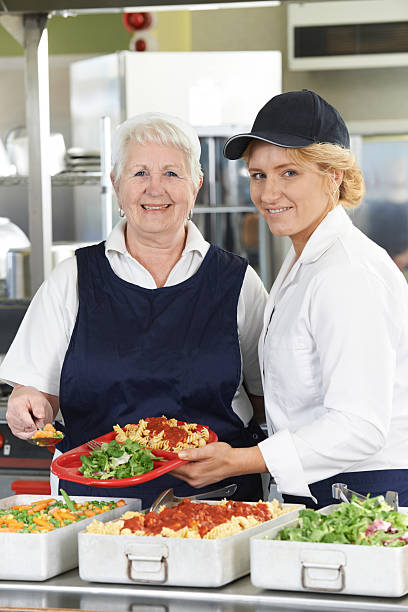 portrait de deux femmes dîner dans la cafétéria de l'école - tabard photos et images de collection