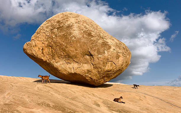 Mamallapuram, Tamil Nadu, India. A large boulder, Krishna's butter ball, named after Hindu God, Krishna, balanced precariously on granite base at Mamallapuram, Tamil Nadu, India. This shot was made on a fine winter's day.