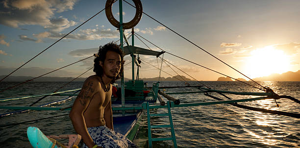 philippino com sua tradicional banca outrigger barcos nas filipinas - outrigger philippines mindanao palawan - fotografias e filmes do acervo
