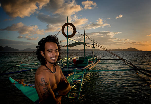 philippino con su tradicional de banca remar embarcaciones en filipinas - outrigger philippines mindanao palawan fotografías e imágenes de stock