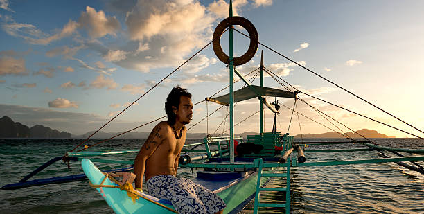 philippino con su tradicional de banca remar embarcaciones en filipinas - outrigger philippines mindanao palawan fotografías e imágenes de stock