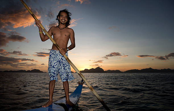 philippino sulla sua tradizionale banca canoa con bilanciere imbarcazioni nelle filippine - nautical vessel philippines mindanao palawan foto e immagini stock