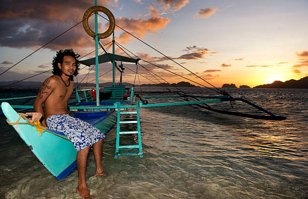 philippino com sua tradicional banca outrigger barcos nas filipinas - outrigger philippines mindanao palawan - fotografias e filmes do acervo