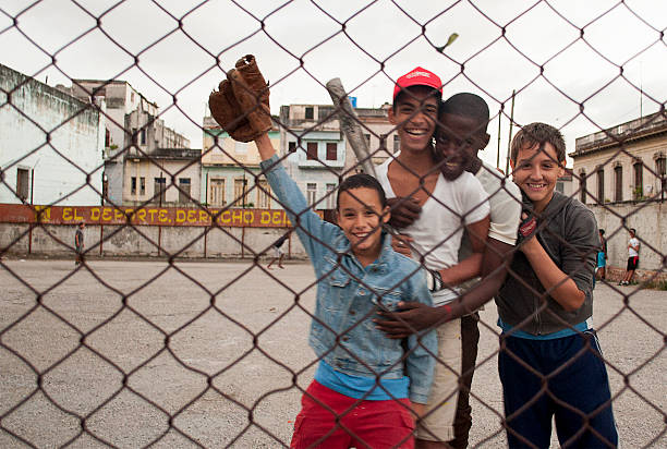 Young black couple dancing salsa on the streets of Trinidad, Cuba while the other girl watching them.