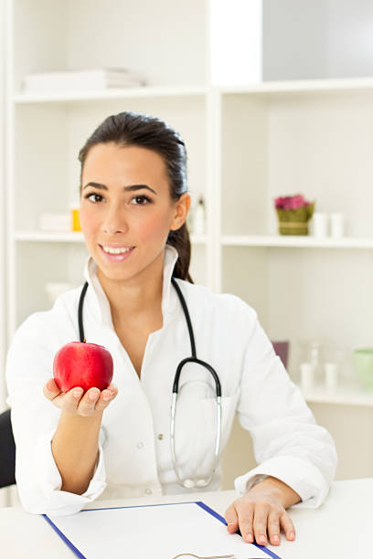 istock Red Apple in a female doctor's hand 471491839