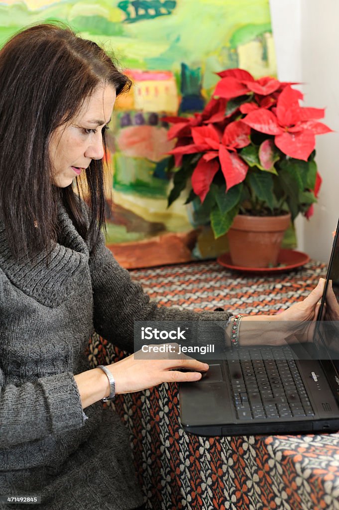 Mujer con ordenador portátil en el estudio - Foto de stock de 50-59 años libre de derechos