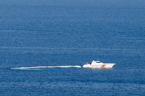 Bodrum, Turkey, September 30, 2012: Turkish flagged speed motor boat going to the coastline of Akyarlar at Bodrum . Three unrecognizable officer in boat. Boat named is \