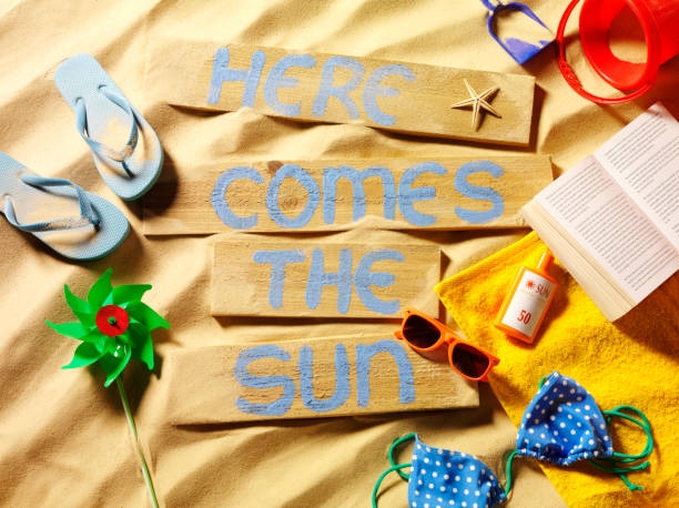 Here Comes the Sun Sign on a Sandy Beach