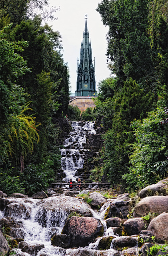 Berlin, Germany - August 18, 2009: People resting and watching the waterfall at the national monument of Kreuzberg hill in Viktoriapark, Berlin. Build by Wilhelm III at 19th September 1818. Architecture by Karl Friedrich Schinkel.