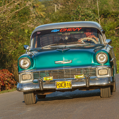 Vinales, Cuba- February 19, 2007: Man driving a vintage chevrolet on the roads around Vinales, a little town in north west Cuba.