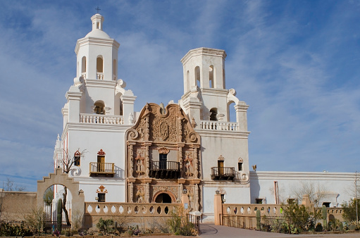 The San Xavier del Bac Mission on the Tohono O'odham Indian Reservation near Tucson, Arizona is captured on a warm spring day.  Nicknamed the 