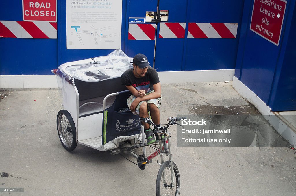 bicycle rickshaw driver taking quick smoke break London England - July 04, 2012 ; bicycle rickshaw driver taking quick smoke break Bicycle Stock Photo