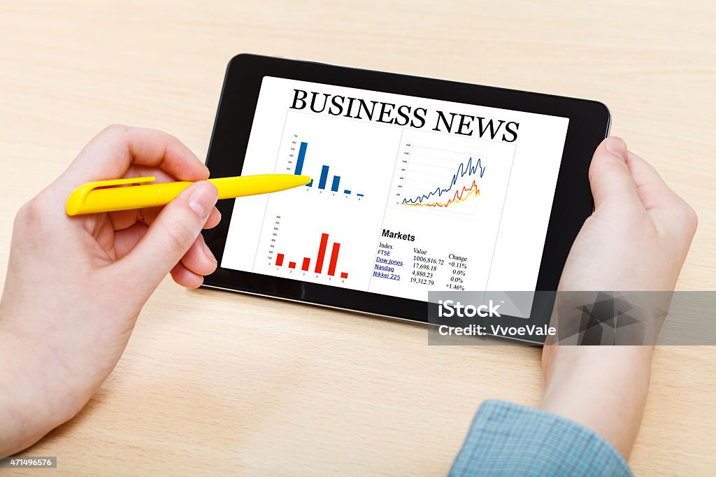 touching by pen of tablet PC with business news businessman touches by pen of tablet PC with business news on screen at office desk 2015 Stock Photo