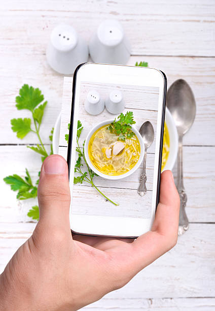 istock Hands taking photo chicken noodle soup with smartphone. 471497378
