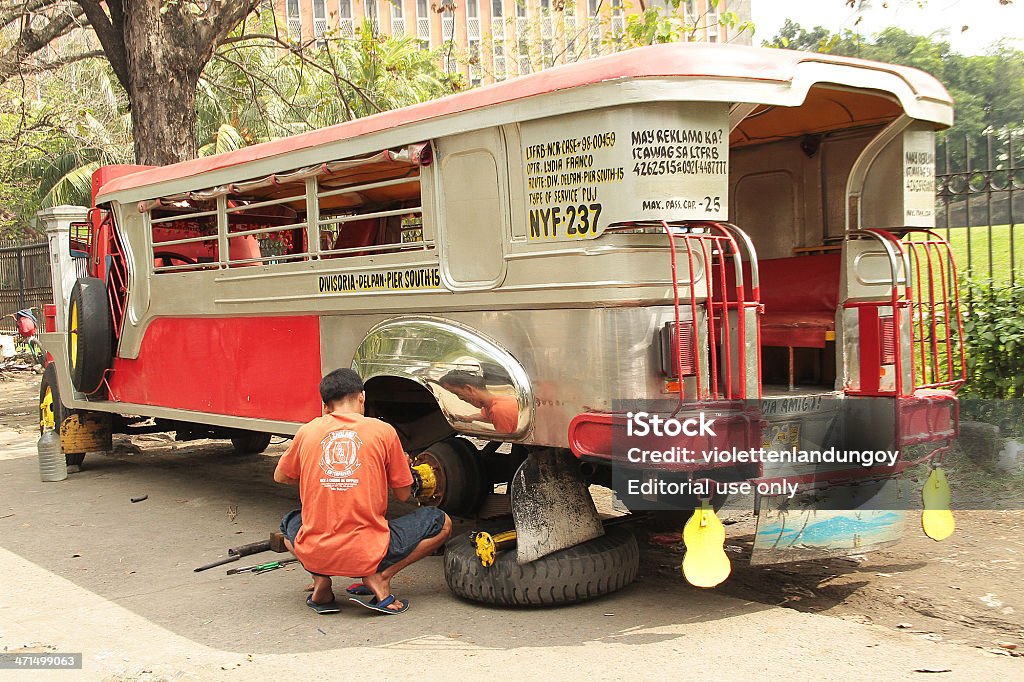 Homme fixation Jeepney roue, Philippines - Photo de Accroupi libre de droits