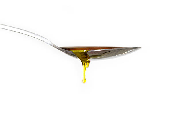 istock Sticky honey drop from spoon on white background 471499171