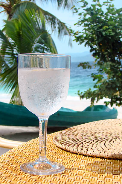 istock Fresh glass of water on a table, tropical beach 471499964