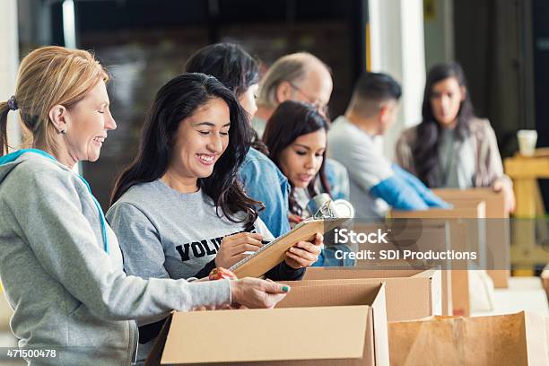 Diversas Adultos Embalaje Cajas De Donación De Caridad Banco De Alimentos Foto de stock y más banco de imágenes de Voluntario