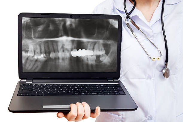 istock nurse holds computer laptop with human jaw 471500710