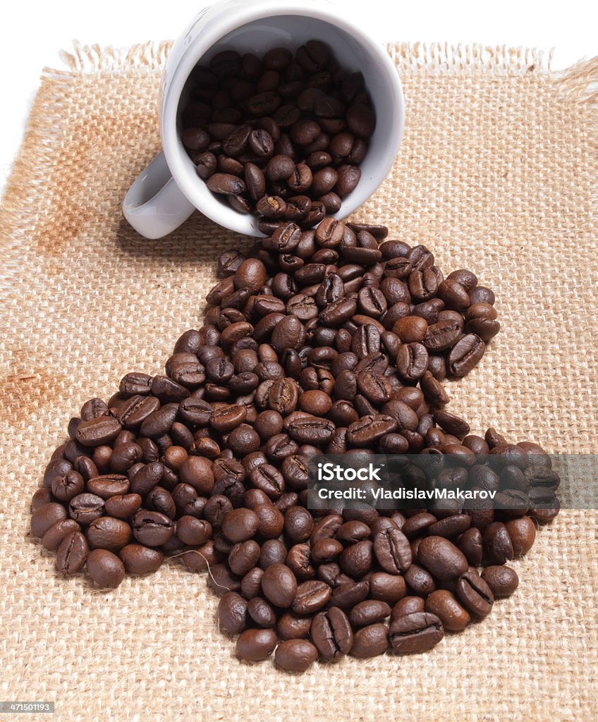 Kubek z stos ziaren kawy z Juta tle - Zbiór zdjęć royalty-free (Bez ludzi)