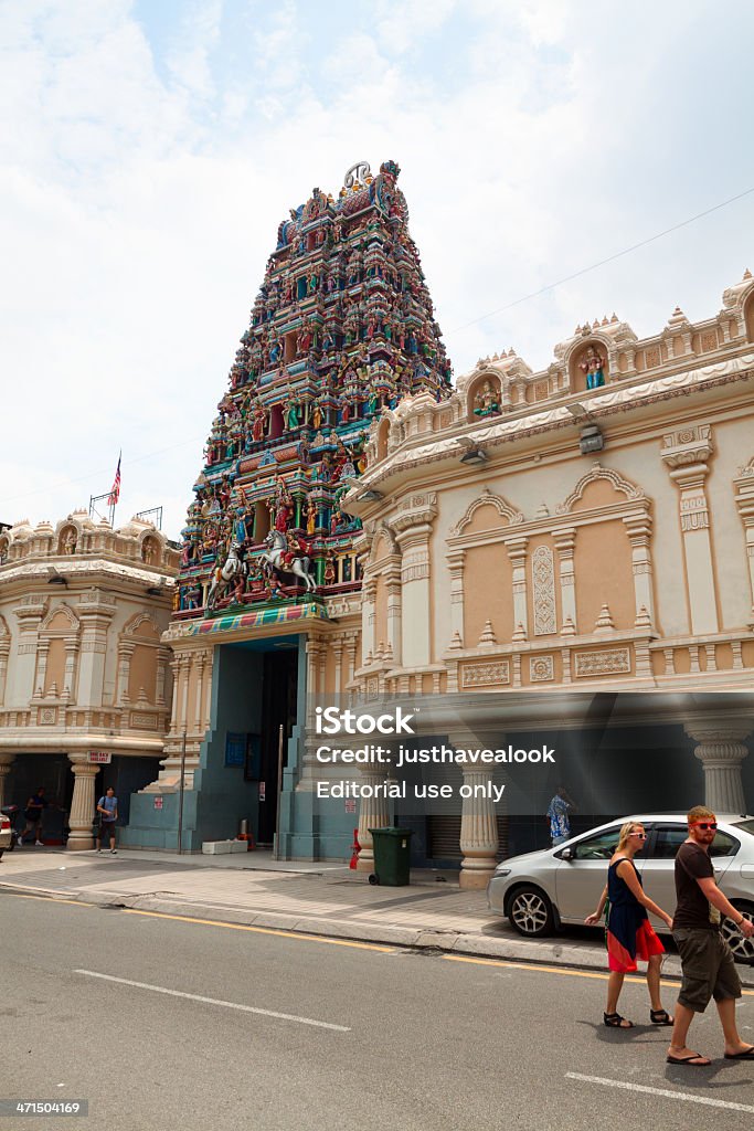 Sri Mahamariamman temple in Kuala Lumpur Kuala Lumpur, Malaysia - September, 9th 2012: Sri Mahamariamman temple in Kuala Lumpur close to Chinatown of Kuala Lumpur. Main entrance with many statues and gods above. At right side is walking a tourist couple and crossing street. Adult Stock Photo