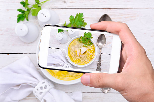 istock Hands taking photo chicken noodle soup with smartphone. 471504202