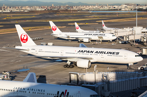 Tokyo, Japan - December 4, 2012: Japan Airlines airplane and JAL Express airplane at Tokyo International Airport (Haneda Airport) in Japan. Some workers are working at the airport area. It is located in Ota Ward, Tokyo, Japan. Tokyo International Airport is the busiest airport in Japan.