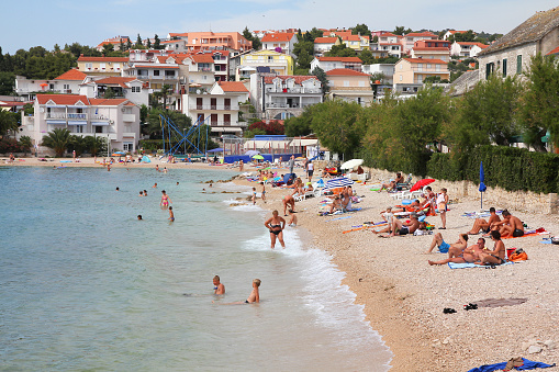 Primosten, Croatia - June 24, 2011: Vacationers enjoy the beach on June 24, 2011 in Primosten, Croatia. In 2011 11.2 million tourists visited Croatia, most of them in summer.