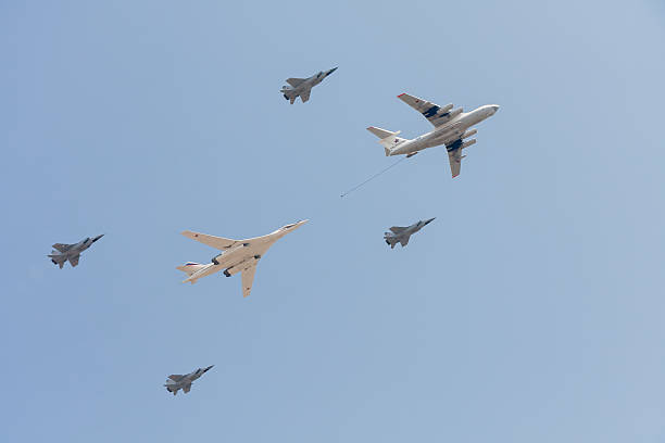 Il-78 flying tanker, Tu-160 bomber, MiG-31 aircrafts demonstrate aerial refueling Moscow, Russia - May 9, 2010: Ilyushin Il-78 (Midas) four-engined aerial refueling tanker and Tupolev Tu-160 (Blackjack) supersonic variable-sweep wing heavy strategic bomber escorted by 4 Mikoyan MiG-31 (Foxhound) supersonic interceptor aircrafts demonstrate refueling against blue sky background on display during parade festivities devoted to 65th anniversary of Victory Day. tu160 stock pictures, royalty-free photos & images