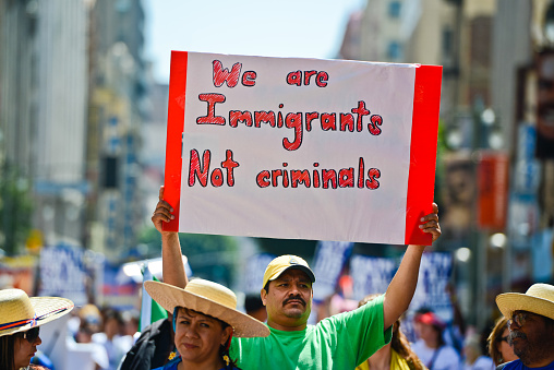 Los Angeles, USA- May 1, 2013: Immigration Reform March on Broadway, 1st May, Los Angeles Downtown. Man in crowd holding Poster  - We are Immigrants Not criminals.