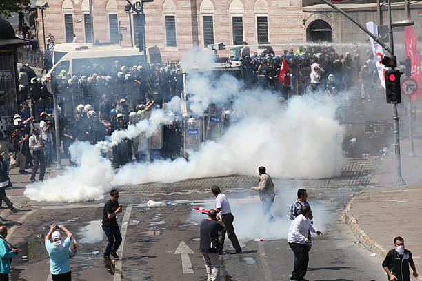 Workers Day in Istanbul Istanbul, Turkey - May1, 2013: The demonstrators who are against to prohibition of 1 May celebration were arrested by the police on May 1,2013 in Istanbul,Turkey tear gas photos stock pictures, royalty-free photos & images