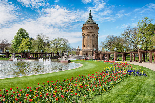 Mannheim water tower, water tower Mannheim, Germany - April 23, 2013: Old water tower in Mannheim. The tower is one of the landmarks in  Mannheim and was erected in 1886 by the architect Gustav Halmhuber. People are enjoying a nice spring day by relaxing in the park. mannheim photos stock pictures, royalty-free photos & images