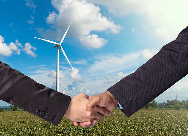 istock Hand shake between a businessman on Wind turbine power generator 471508474