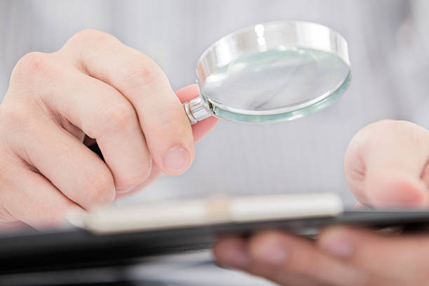istock Businessman looking through a magnifying glass 471510545