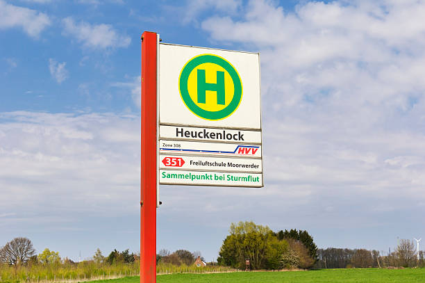 Hamburg, Germany - May 2, 2013: View to a bus stop sign from the HVV in Hamburg-Wilhelmsburg, station Heuckenlock, in the near of the dyke. Important is the German sentence Sammelpunkt bei Sturmflut, in English it means Assembly point when a storm surge disaster is coming. This is a result after the big North Sea flood of 1962 in Hamburg-Wilhelmsburg when about hundred of buildings were destroyed.