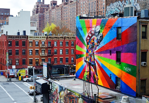 New York, New York, USA - April 13, 2013: Traffic in Chelsea by a mural by artist Brazilian artist Kobra. The colorful mural is based on Alfred Eisenstaedt's photo from V-J Day in Times Square.