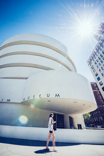 New York, United States - May 2, 2013: Woman walks by the Guggenheim Museum under the midday sun.