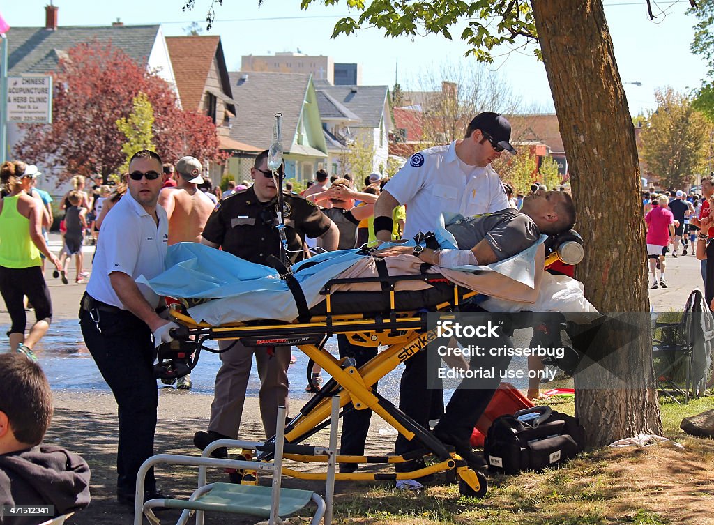 Man Being Treated for Exhaustion by EMTs Bloomsday 2013 Spokane, USA - May 5, 2013. Runner being treated for exhaustion by EMTs during Bloomsday, an annual timed road race held on the first Sunday of every May. Paramedic Stock Photo