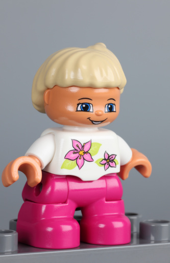 Tambov, Russian Federation - February 28, 2013: Lego Duplo blonde girl figure on grey background. Studio shot.