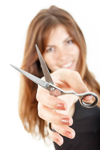 istock Attractive young woman with scissors pointing at you 471515536