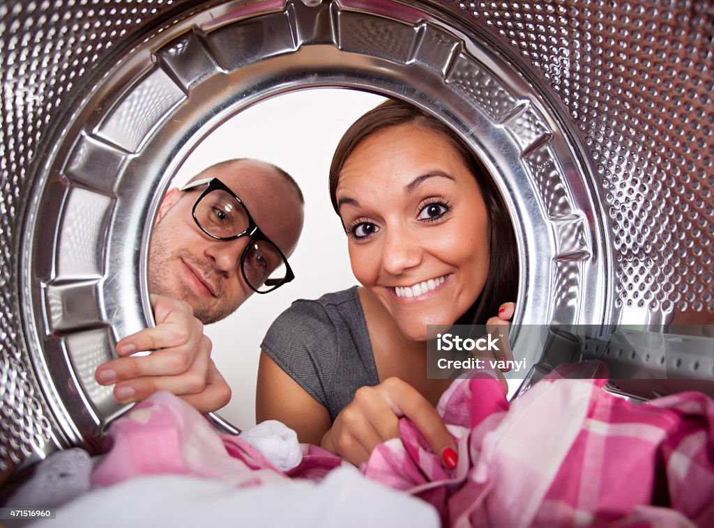 Young couple doing laundry Young couple doing laundry View from the inside of washing machine. Couple - Relationship Stock Photo