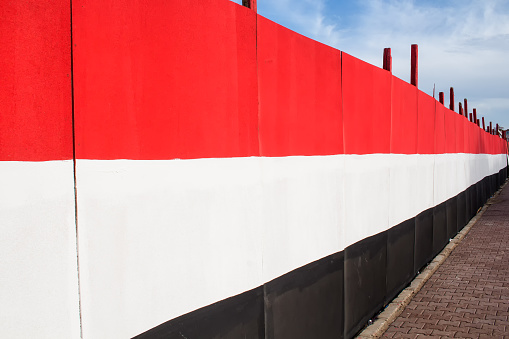 Perspective view on the fence decorated in the design of egyptian national flag.