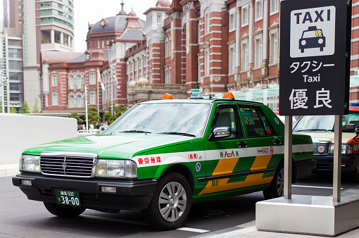 Tokyo, Japan - April 29, 2013: A taxi parked in the line of taxis in front of Tokyo Station.  Tokyo Station is in the Marunouchi business district and is located close to the Ginza commercial district and the Imperial Palace grounds.