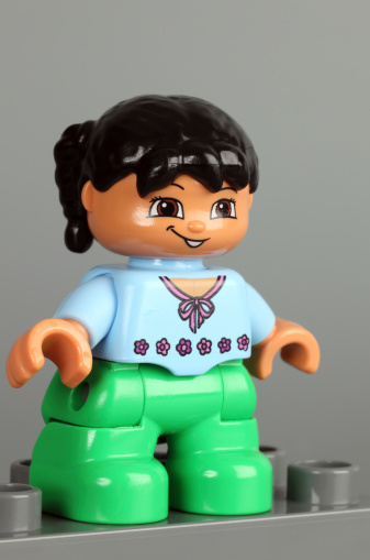 Tambov, Russian Federation - February 28, 2013: Lego Duplo brunette girl figure on gray background. Studio shot.